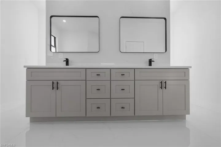 Bathroom with dual vanity and tile patterned floors