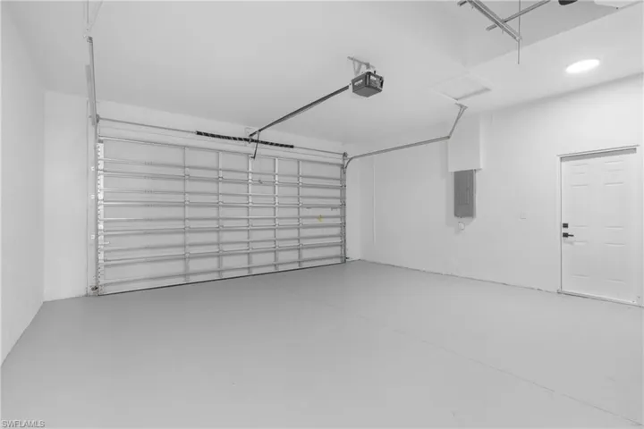 Garage featuring electric panel and a garage door opener