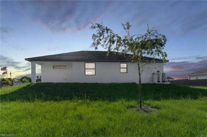 Property exterior at dusk with a yard