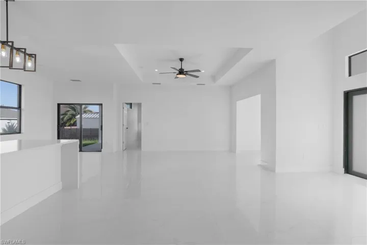 Unfurnished room with ceiling fan, a raised ceiling, and tile patterned floors