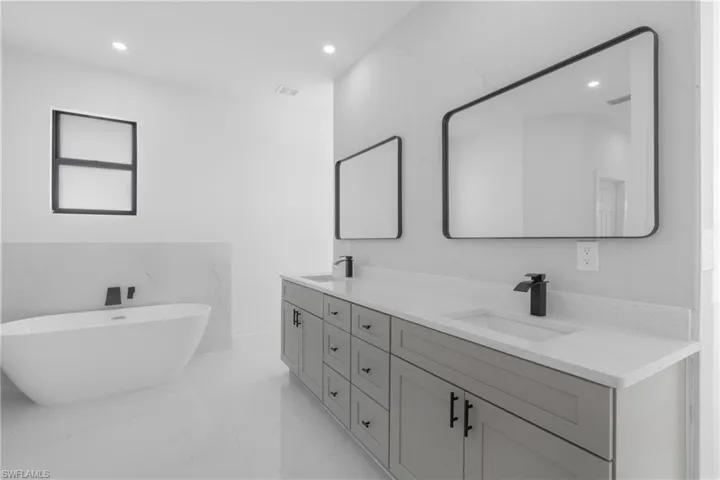 Bathroom with double sink vanity, tile walls, and tile patterned flooring