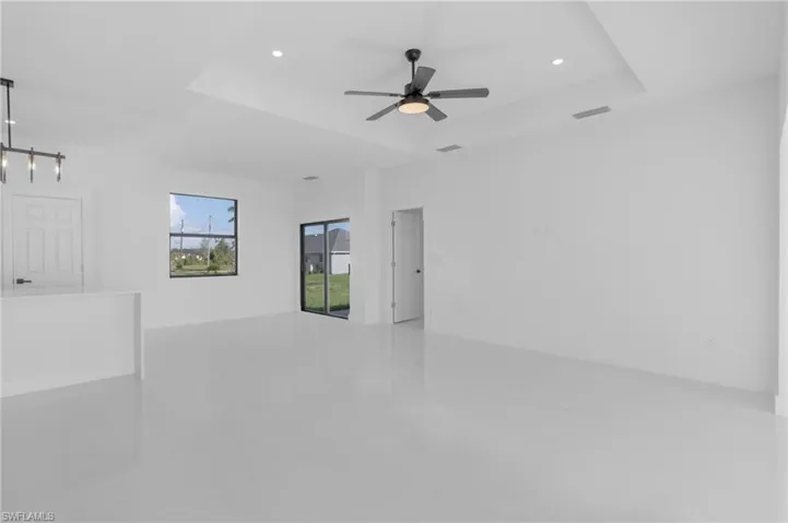 Unfurnished room featuring a tray ceiling and ceiling fan
