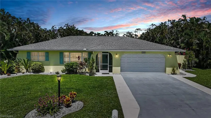 Ranch-style home featuring stucco siding, a lawn, driveway, and a garage