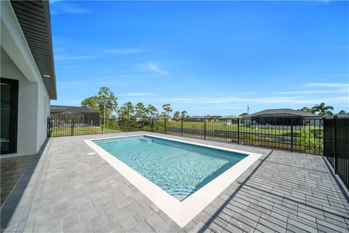View of swimming pool featuring patio surround, a fenced backyard, and a residential view
