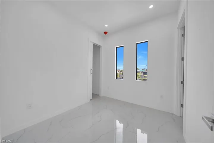 Unfurnished room featuring recessed lighting and light marble finish flooring