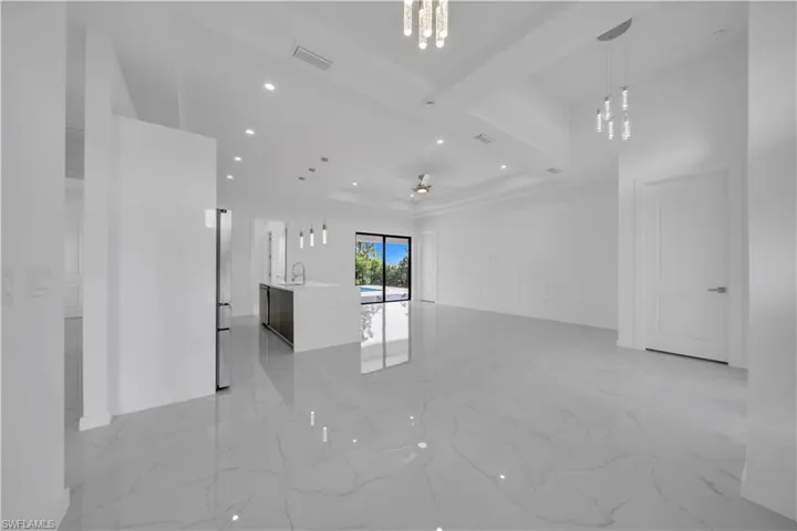Unfurnished living room featuring recessed lighting, light marble finish floors, and a ceiling fan