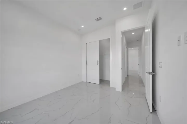 Unfurnished bedroom with recessed lighting, a closet, and light marble finish floors