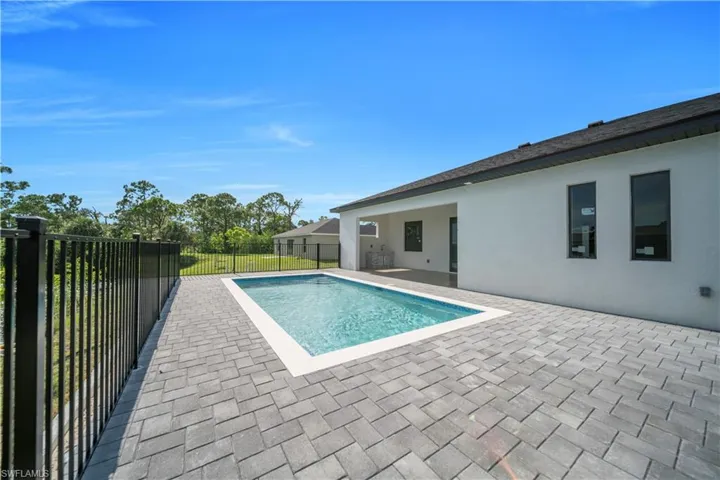 View of swimming pool with patio surround and a fenced backyard