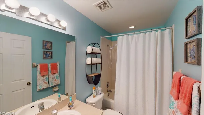 Bathroom featuring shower / bath combo with shower curtain and vanity