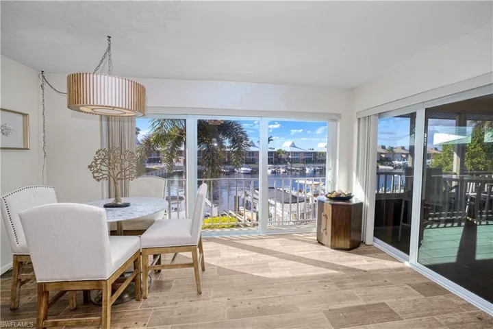 Dining space with a water view, wood finished floors, and plenty of natural light