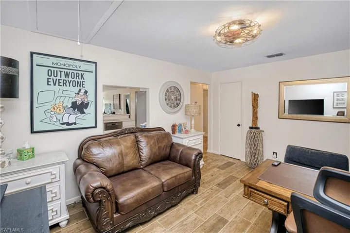 Living room with a desk, attic access, and wood tiled floors