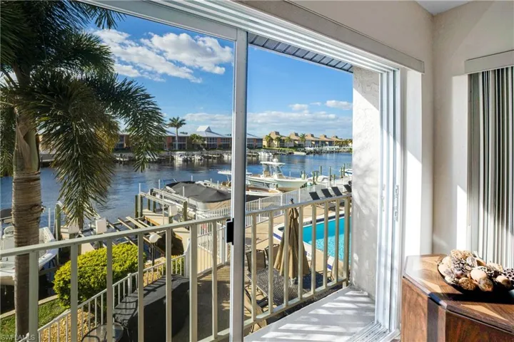 Balcony featuring view of pool area, a water view, and boat lift