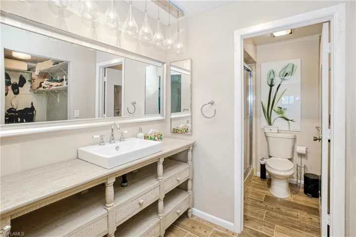 Full bath with a stall shower, wood tiled floors, and vanity