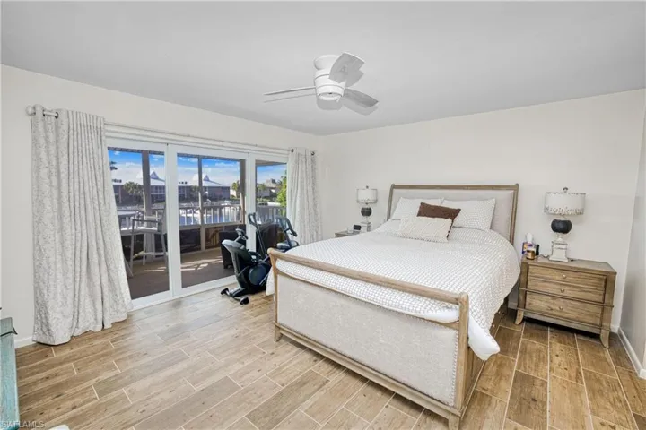 Bedroom with access to outside, wood finish floors, and a ceiling fan