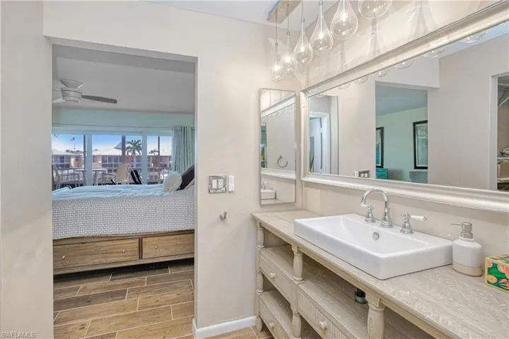 Ensuite bathroom with wood tiled floors, vanity, and a ceiling fan