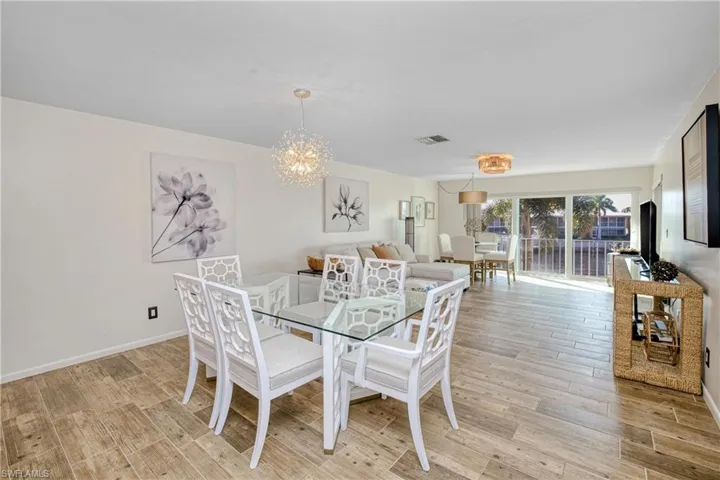 Dining room with wood tiled floors and a chandelier