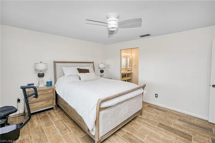 Bedroom with wood tiled floors and a ceiling fan