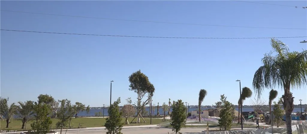 View of asphalt street featuring street lights, curbs, and sidewalks