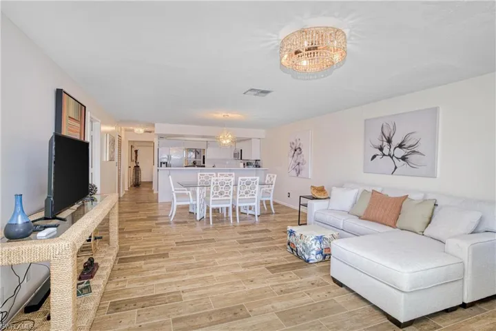 Living area with wood tiled floors and a chandelier