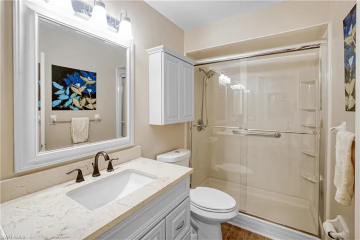 Full bathroom with vanity and a shower stall