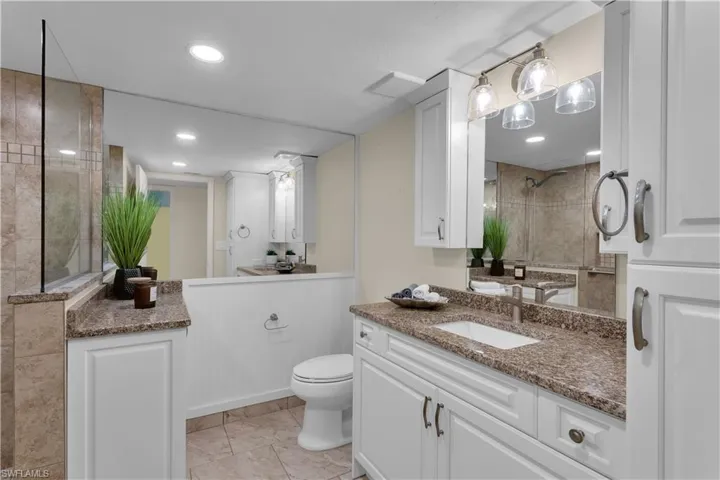 Hallway bathroom completely remodeled withgranite countertop and white cabinets