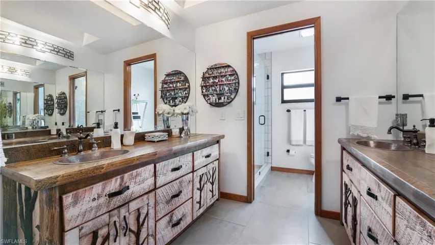 Bathroom with vanity, a stall shower, and light tile patterned floors