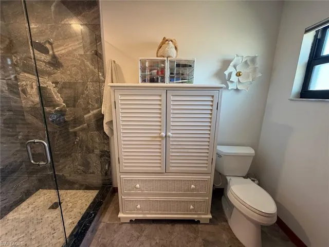 Bathroom featuring a shower stall and toilet