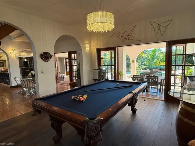 Playroom featuring billiards, arched walkways, and wood finished floors