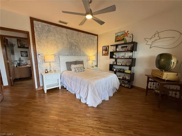Bedroom with dark wood finished floors and ceiling fan