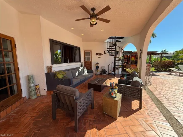 View of patio with an outdoor living space with a fire pit, stairway, and a ceiling fan