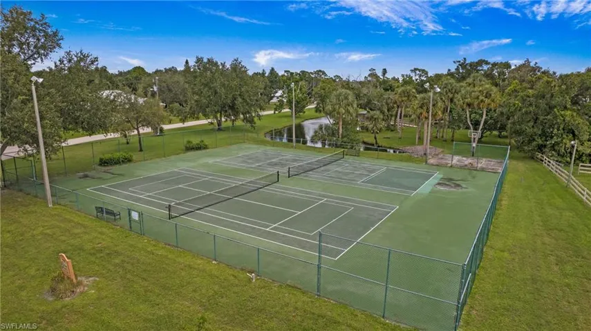 View of tennis court featuring view of scattered trees