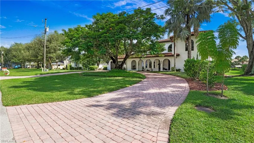 Mediterranean / spanish-style home with a front lawn, stucco siding, and a tiled roof