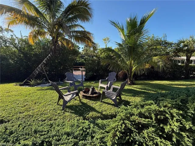 View of green lawn featuring a fire pit