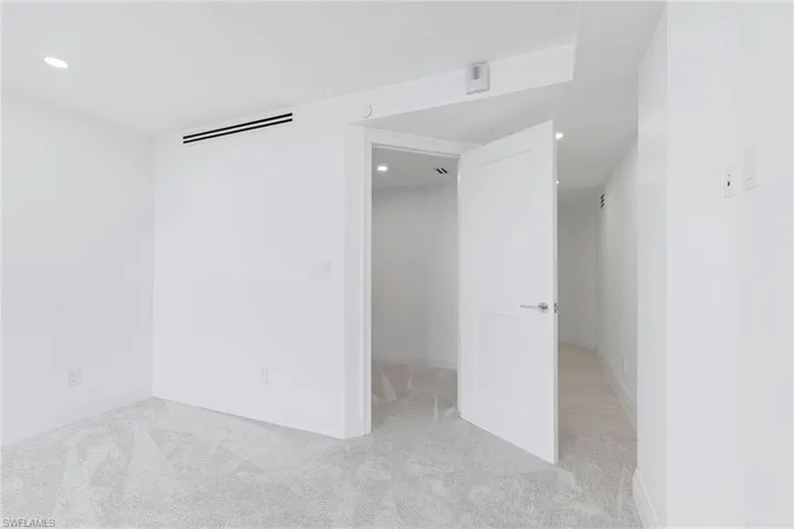 Unfurnished bedroom with light carpet and recessed lighting