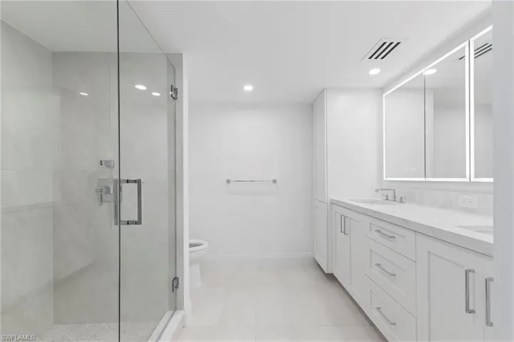 Full bath with double vanity, a shower stall, recessed lighting, and light tile patterned flooring