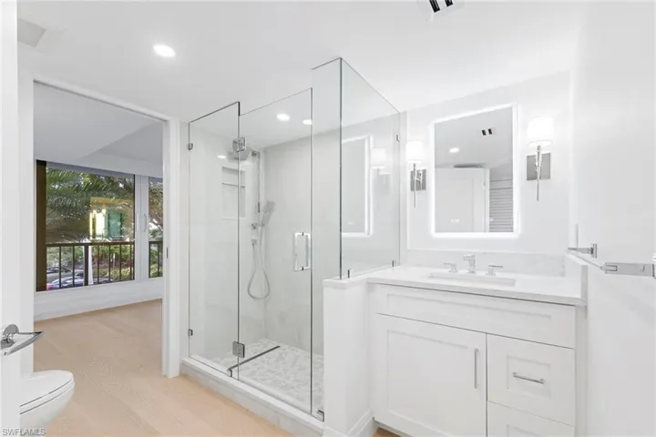 Bathroom with vanity, a shower stall, light wood-type flooring, and recessed lighting