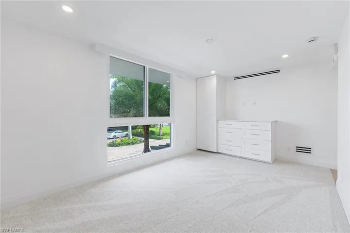 Unfurnished bedroom with light colored carpet and recessed lighting