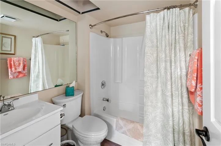 Full bathroom featuring vanity, shower / bath combination with curtain, and toilet