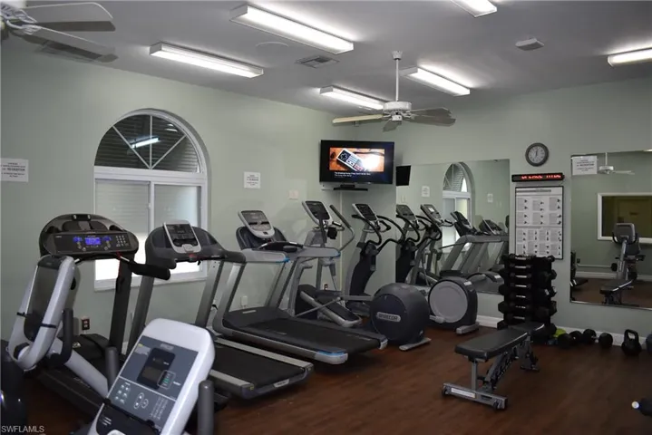 Gym with ceiling fan and dark hardwood / wood-style flooring