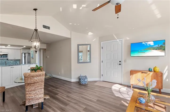 Living room with vaulted ceiling, hardwood / wood-style flooring, and ceiling fan