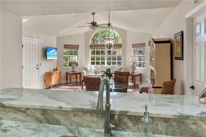Dining room featuring ceiling fan with notable chandelier, lofted ceiling, and wood-type flooring
