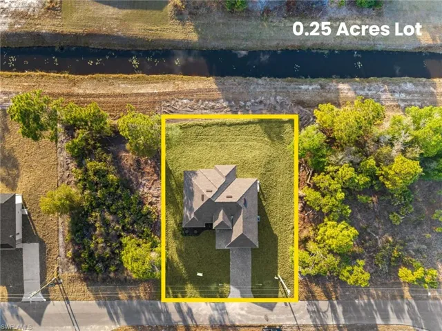 Aerial view of property and surrounding area featuring a nearby body of water and property parcel outlined