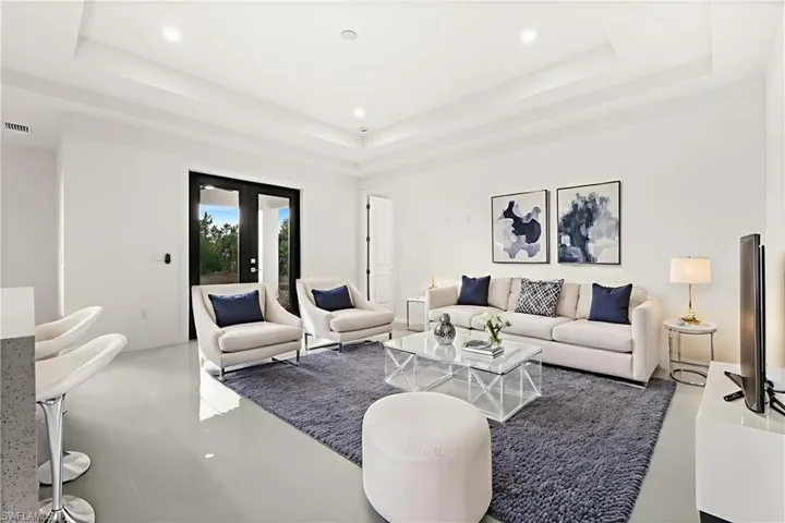 Living area featuring french doors, tile patterned floors, recessed lighting, and a tray ceiling