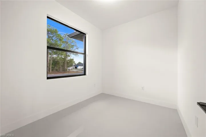 Unfurnished room with baseboards and concrete flooring