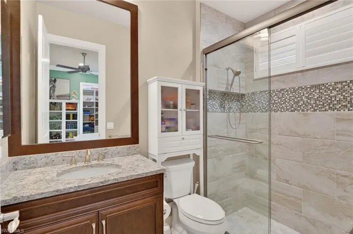 Bathroom featuring a dark wood vanity with a light speckled countertop and undermount sink