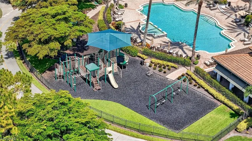 Community playground featuring multiple play structures with slides, swings, and a protective canopy
