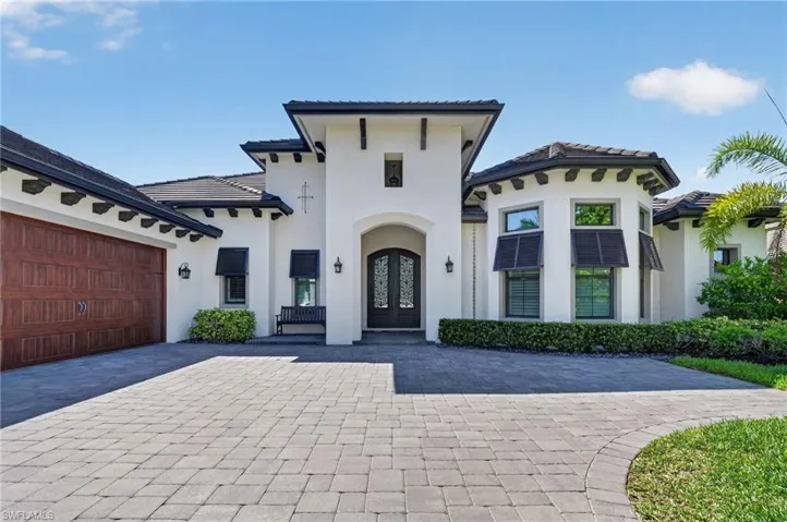 White stucco exterior with dark tile roofing and decorative corbels