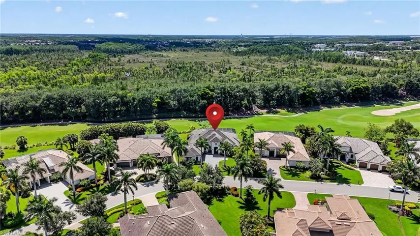 Aerial perspective showcasing a residential community bordered by a golf course and natural preserve