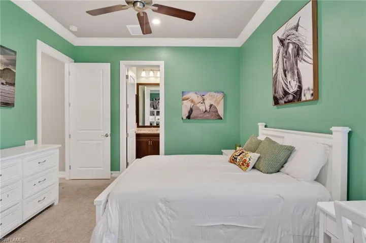 Bedroom featuring crown molding, neutral carpeting, and a ceiling fan