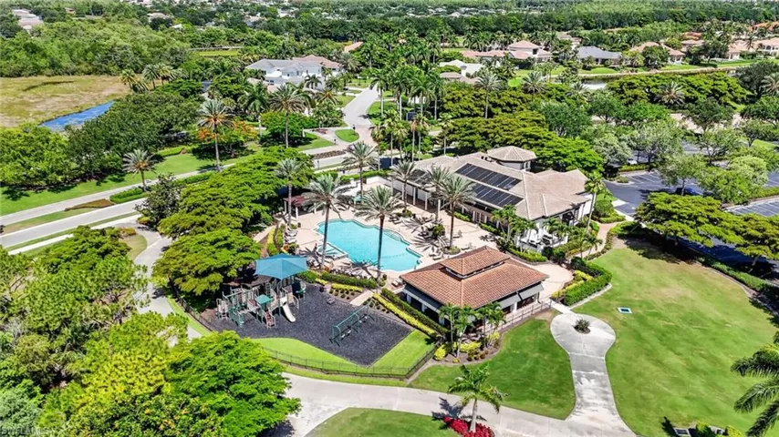 Expansive community amenities featuring a large resort-style swimming pool, sun deck, and a separate shaded playground area